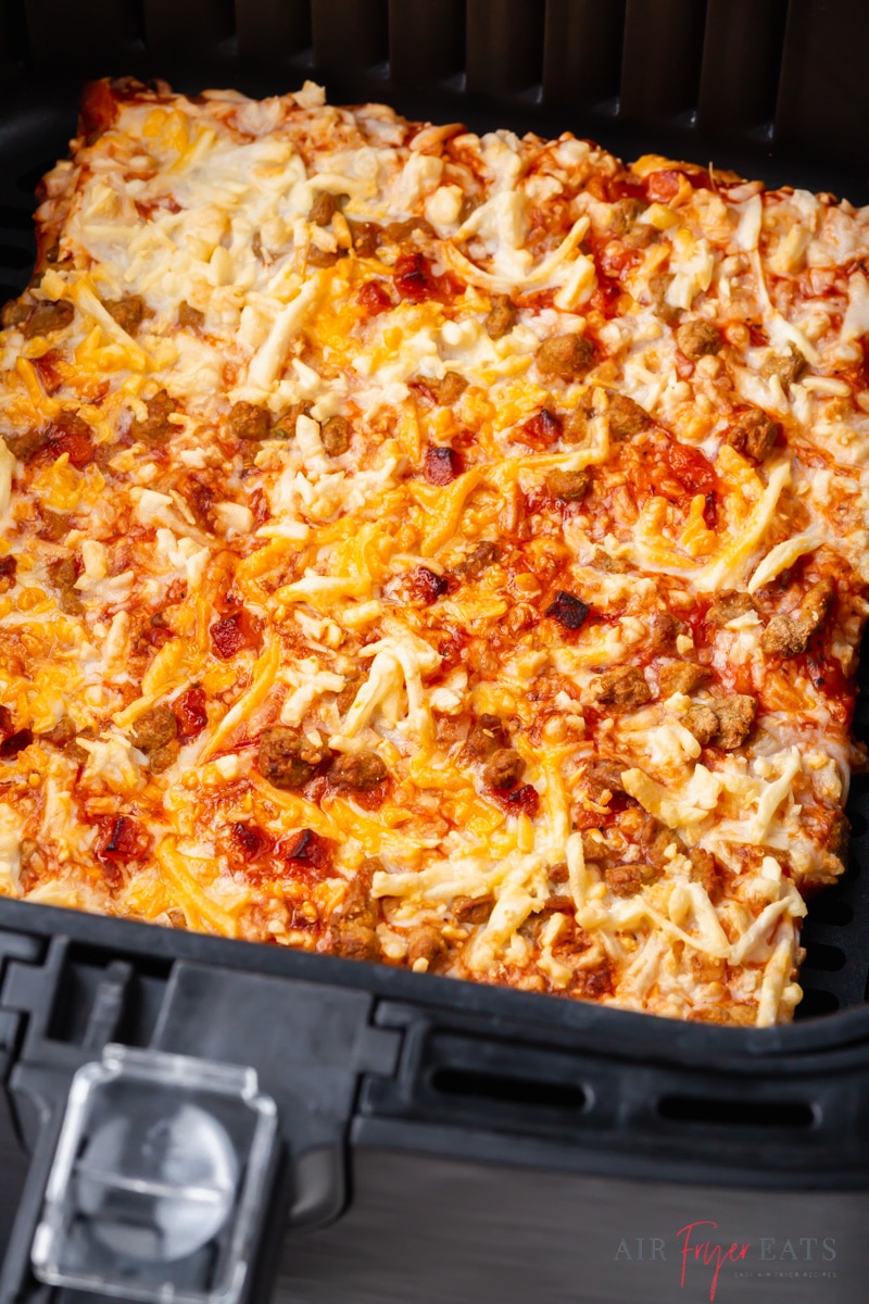 Close-up shot of a cooked Totino's pizza in an air fryer basket