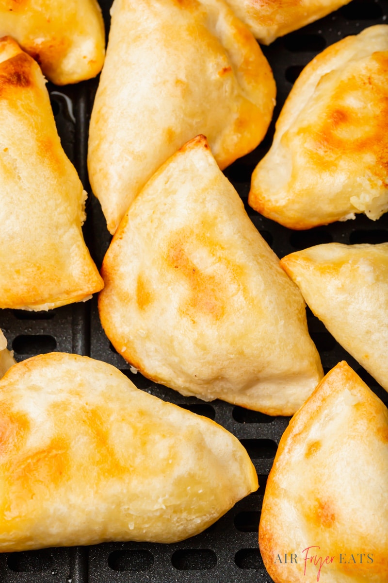 closeup view of frozen pierogies in air fryer basket