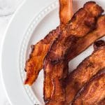 Crispy bacon strips on a white plate