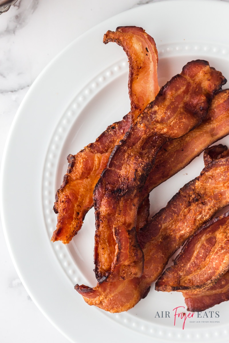 Crispy bacon strips on a white plate