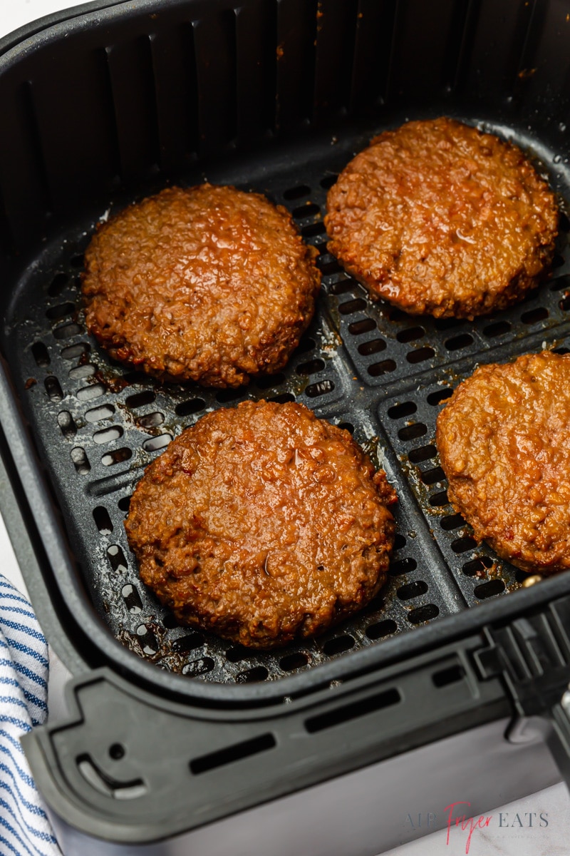 four beyond burger patties cooked in an air fryer basket