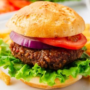 A beyond burger on a bun with leaf lettuce, tomato, and red onion