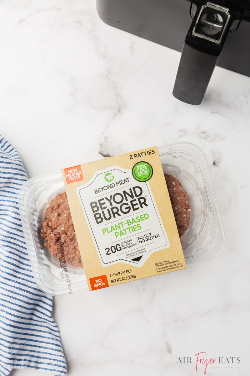 a package of beyond burgers on a counter next to an air fryer, viewed from above