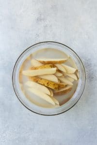 sliced fries in glass bowl with water