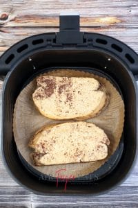 Bread slices sat in air fryer basket, ready to be air fried