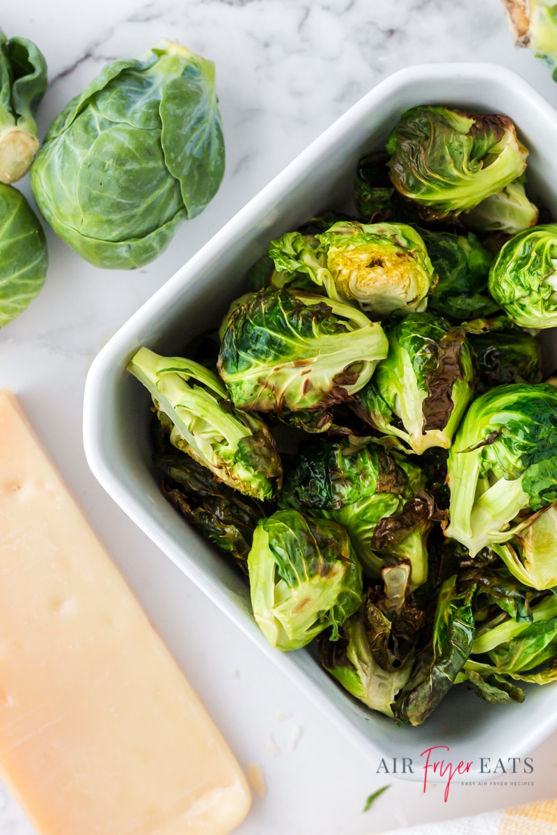 a square dish filled with crispy air fryer brussels made in the ninja foodi. Viewed from above.