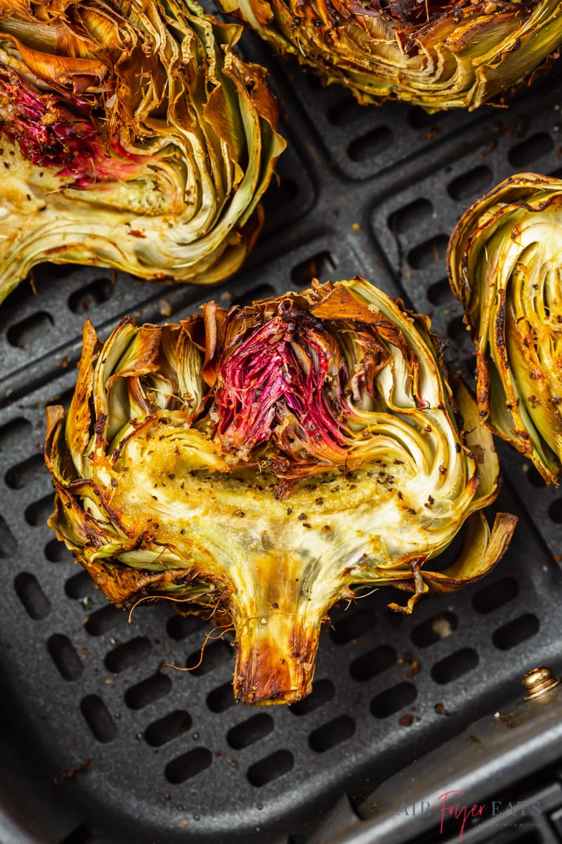 halved artichokes in an air fryer basket