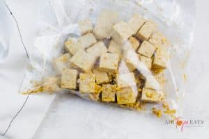 Cubed tofu in a clear ziplock bag, marinating in sticky ginger coating