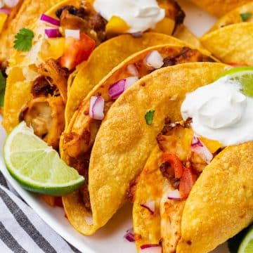 closeup view of a platter of air fryer chicken tacos with toppings