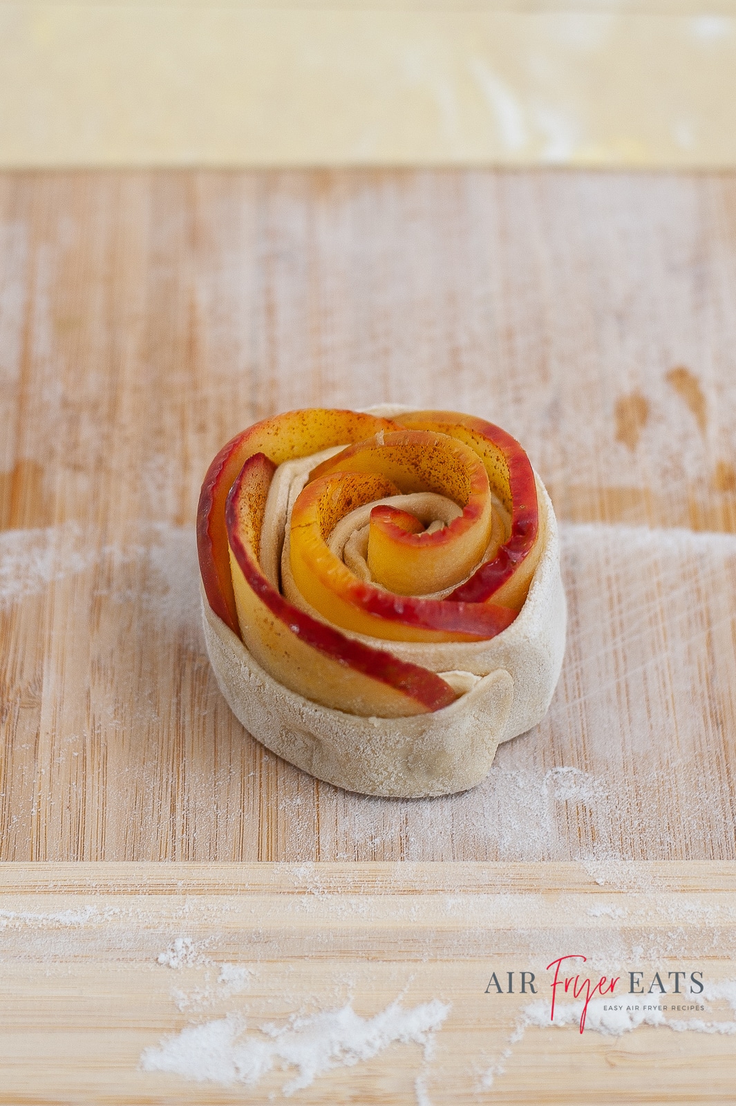 A single apple rose ona. brown cutting board