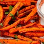 closeup view of crispy air fryer carrot fries, garnished with fresh parsley