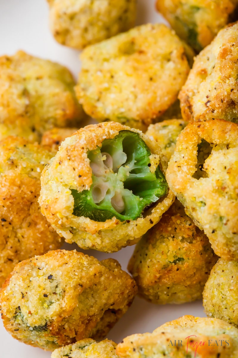 closeup of a plate of air fryer frozen okra. One pice has been bitten to show the interior texture.