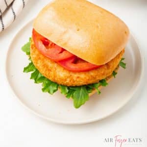 chicken patty sandwich on a square bun with lettuce and tomato slices.