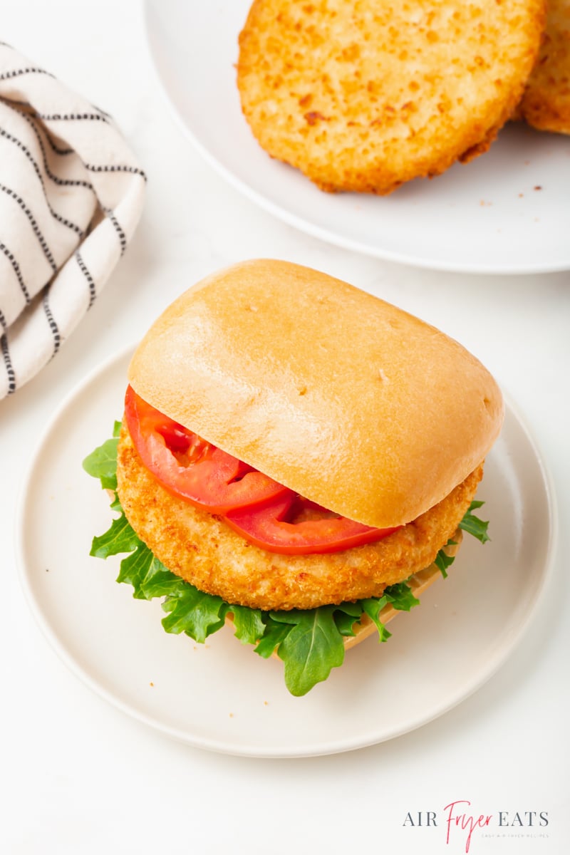 chicken patty sandwich on a square bun with lettuce and tomato slices.