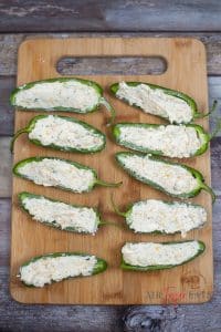 vertical image of jalapeno pepper halves filled with cheese mix