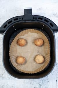 Air fryer basket with 4 balls of cookie dough inside