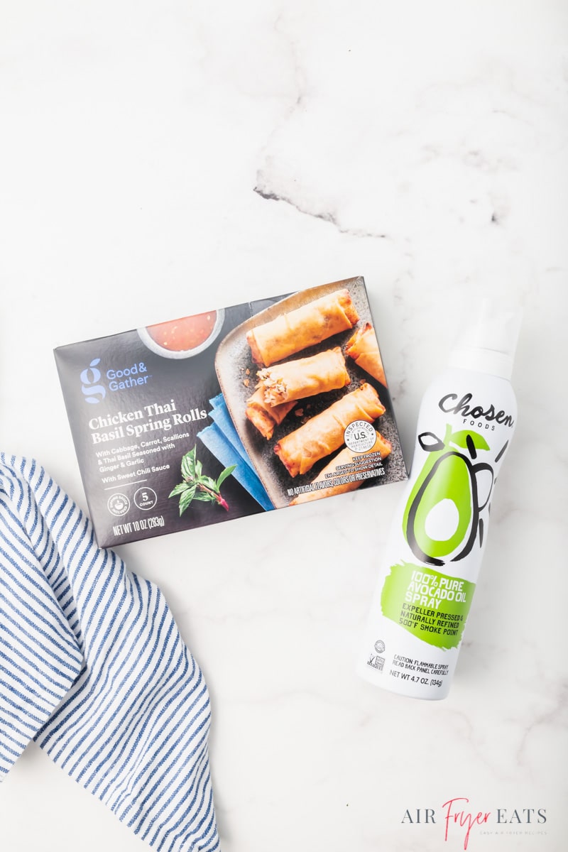 a box of frozen spring rolls and a bottle of avocado oil spray on a counter, viewed from overhead.