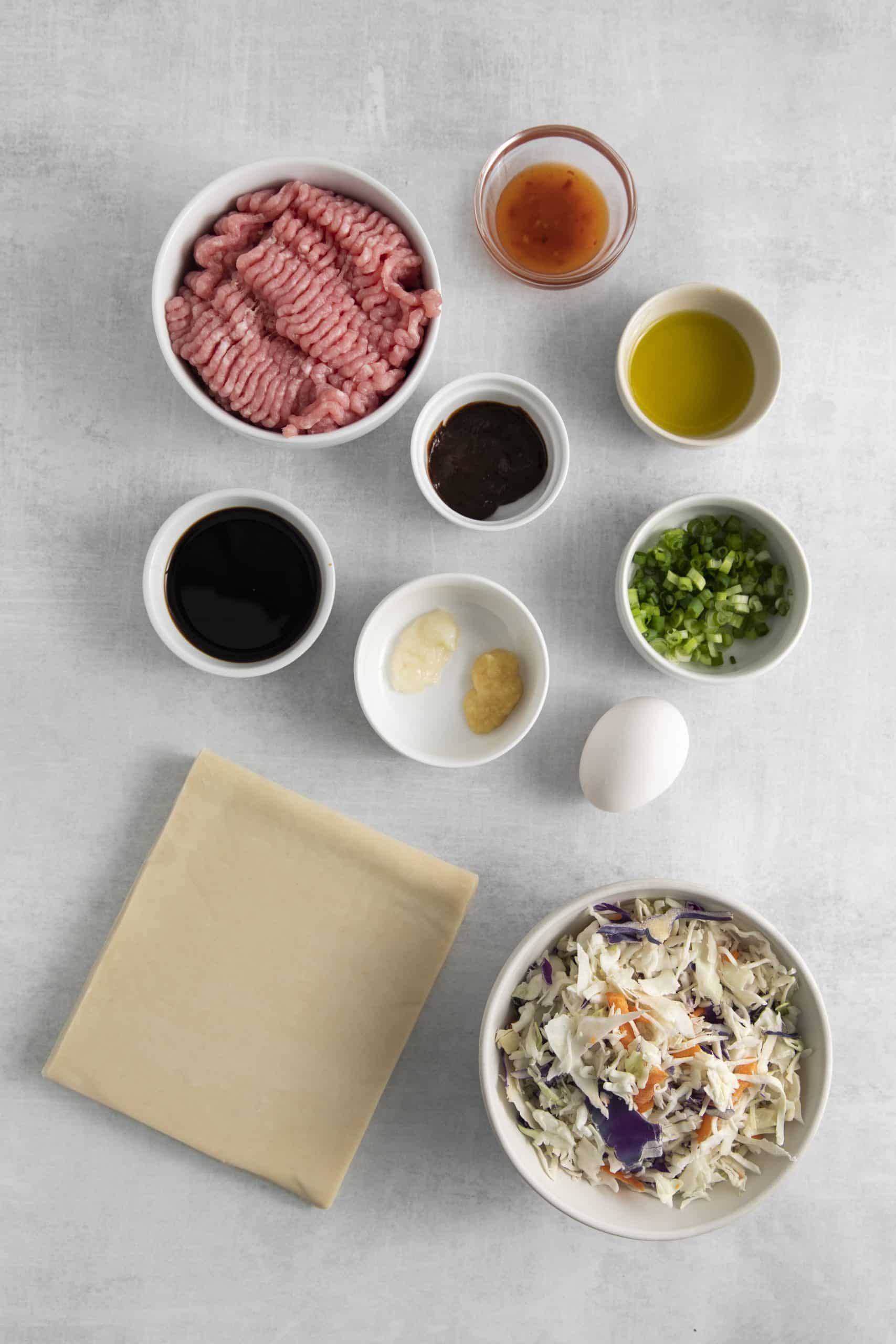 Top view photo of ingredients to make Air Fryer Egg Rolls in separate bowls. 