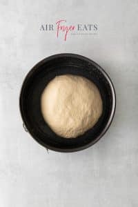 Top view photo of the dough to make Air Fryer Bread in a 6" round pan, and ready to rise until doubled in size.