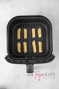 Top view photo of an air fryer basket filled with Air Fryer Churro dough, ready to cook.
