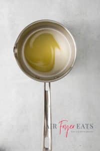Top view photo of a saucepan filled with butter, sugar, water, and salt, and mixed until combined over medium heat.