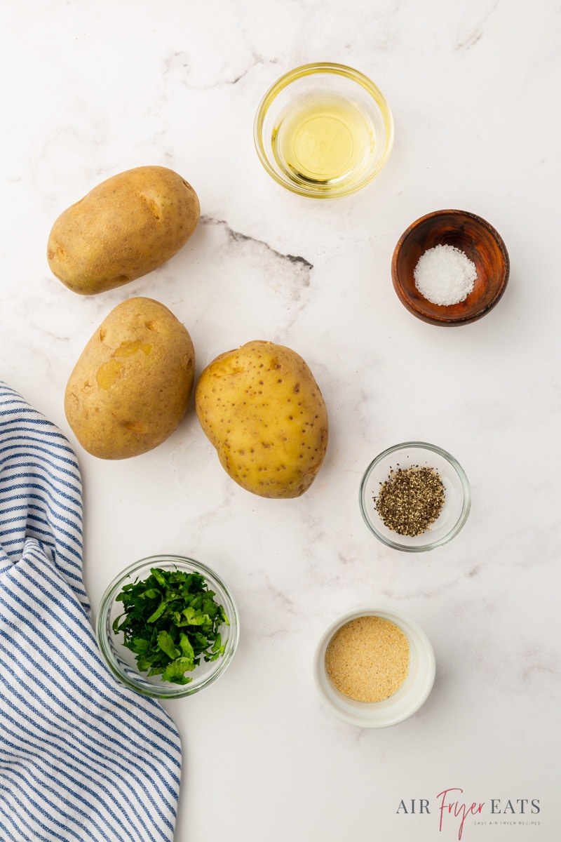 Three russet potatoes and the other ingredients needed to make french fries in air fryer. 