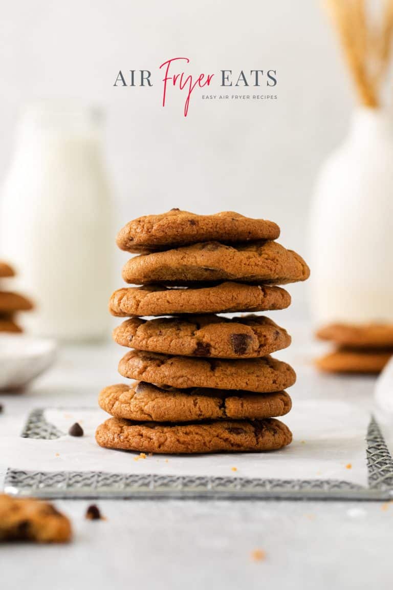 Photo of a stack of cookies that were made using the air fryer. They are stacked on a cooling rack lined with parchment paper.