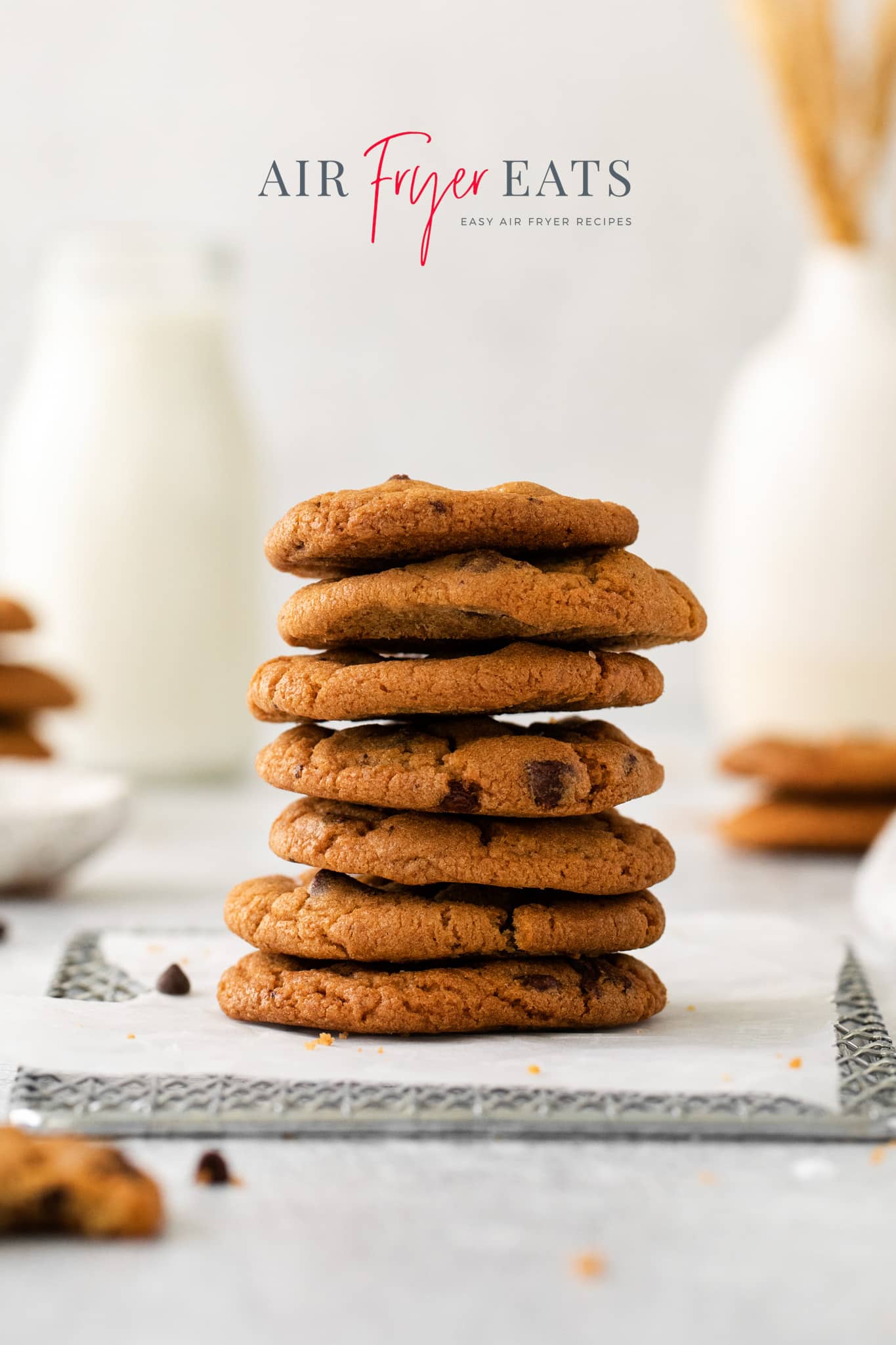Photo of a stack of cookies that were made using the air fryer. They are stacked on a cooling rack lined with parchment paper. 