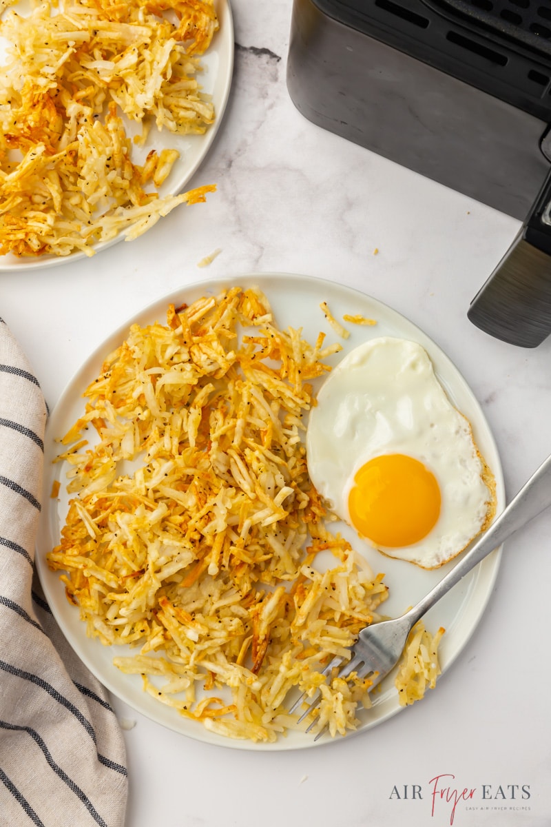 Hash browns on a plate with a fried egg. 