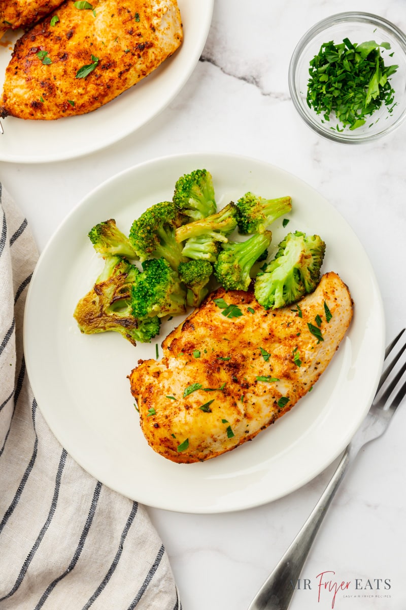 a dinner plate with roasted broccoli and air fried frozen chicken breast.