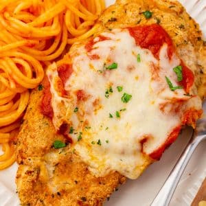 Closeup of a breaded chicken parmesan cutlet topped with tomato sauce and mozzarella cheese.