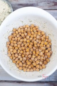 vertical photo showing a large white bowl with chickpeas coated in ranch seasoning