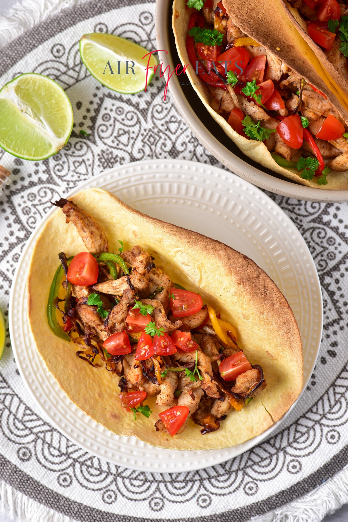 a crispy tortilla filled with air fryer chicken fajitas, topped with diced tomatoes and cilantro.