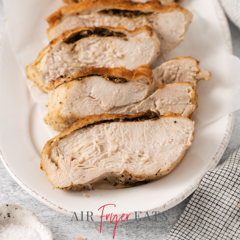 sliced air fried turkey breast with skin on a platter.