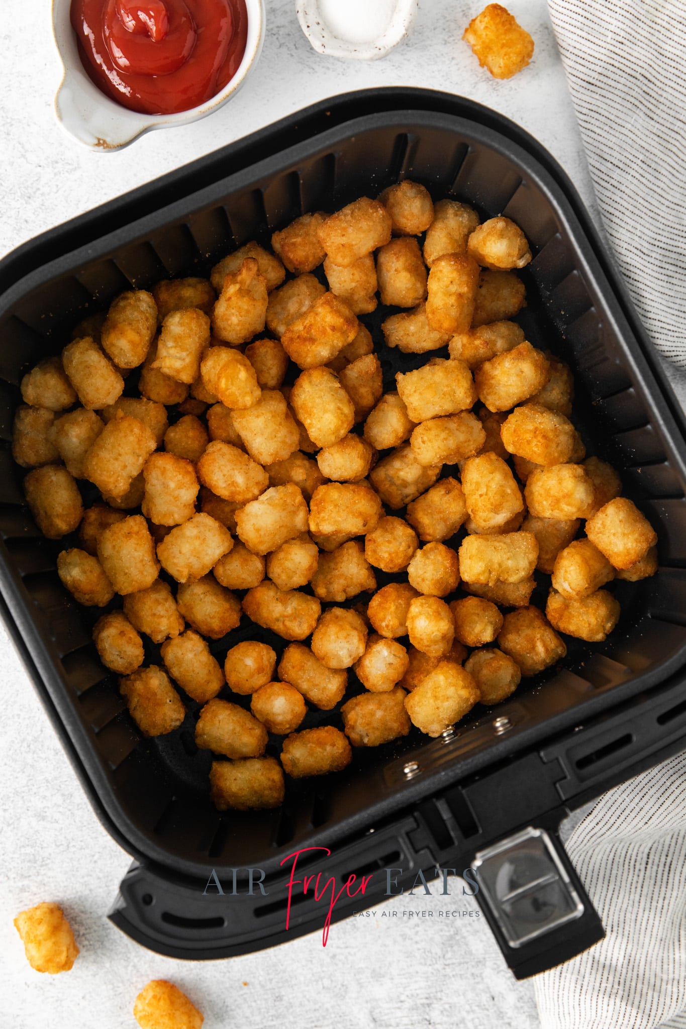 a square air fryer basket of tater tots