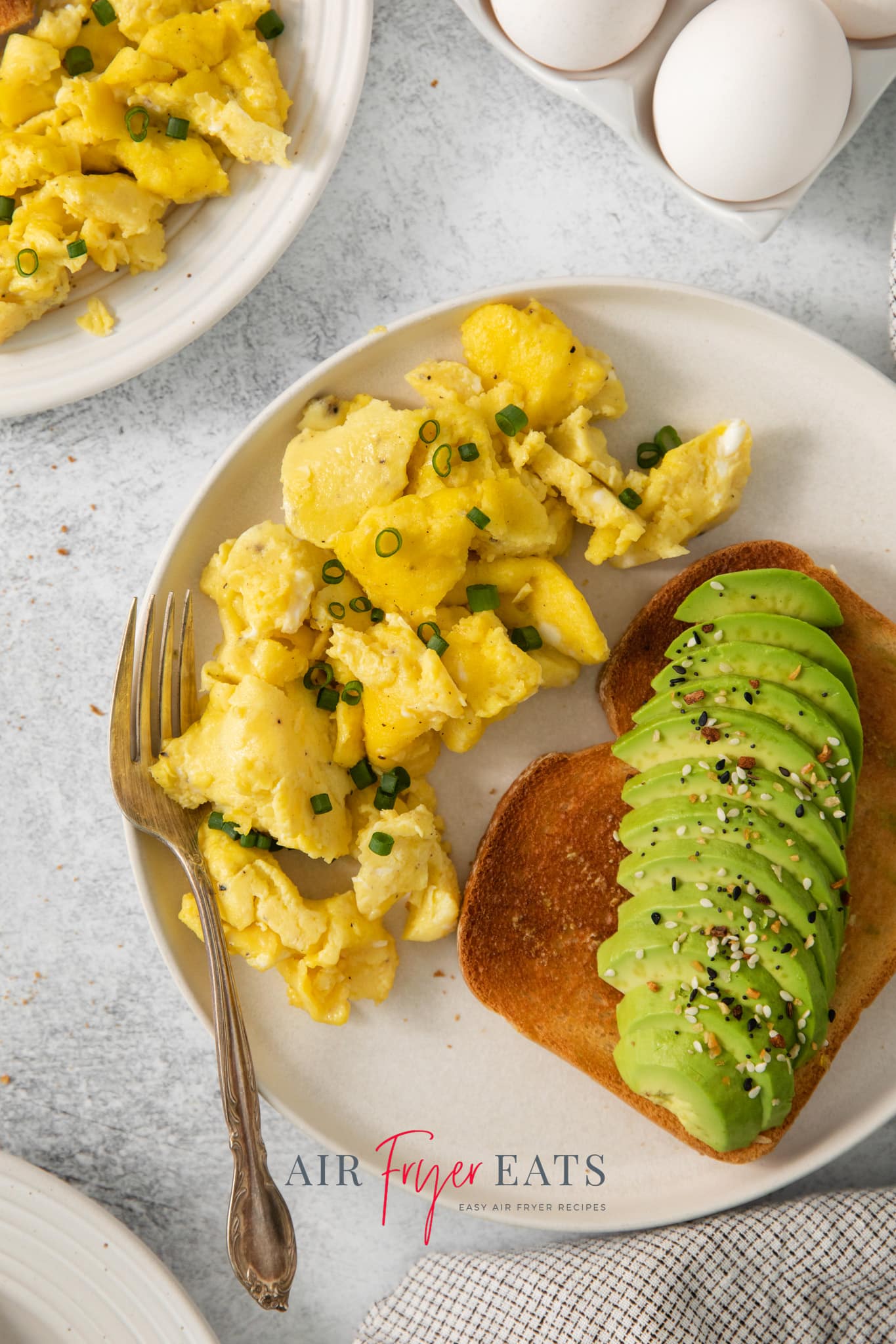overhead view of a plate with air fryer scrambled eggs and avocado toast.