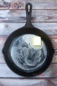 vertical photo of the butter melting in a pan for the sauce mix